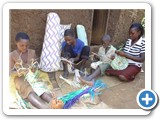 Family members making mats for income generation. The material is from palm trees